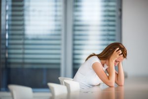 Anxious woman at a table at work.