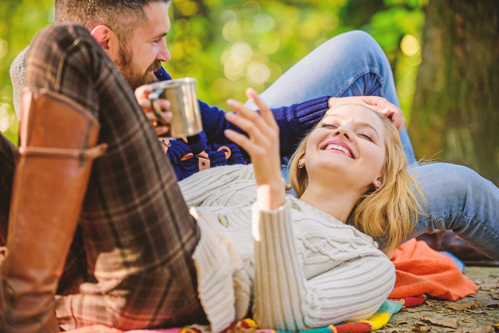 Cheerful couple. couple in love relax in autumn forest with tea or coffee. camping and hiking. 