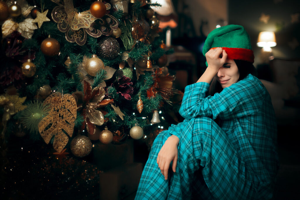 Sad Upset Lonely Woman Crying Next to Her Christmas Tree in her pajamas